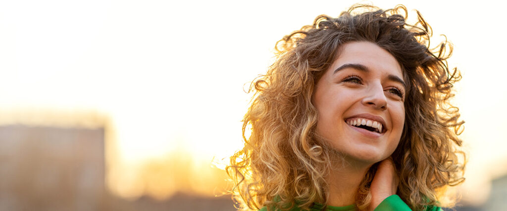 a woman smiles and feels good to be happy healthy and well after addiction treatment
